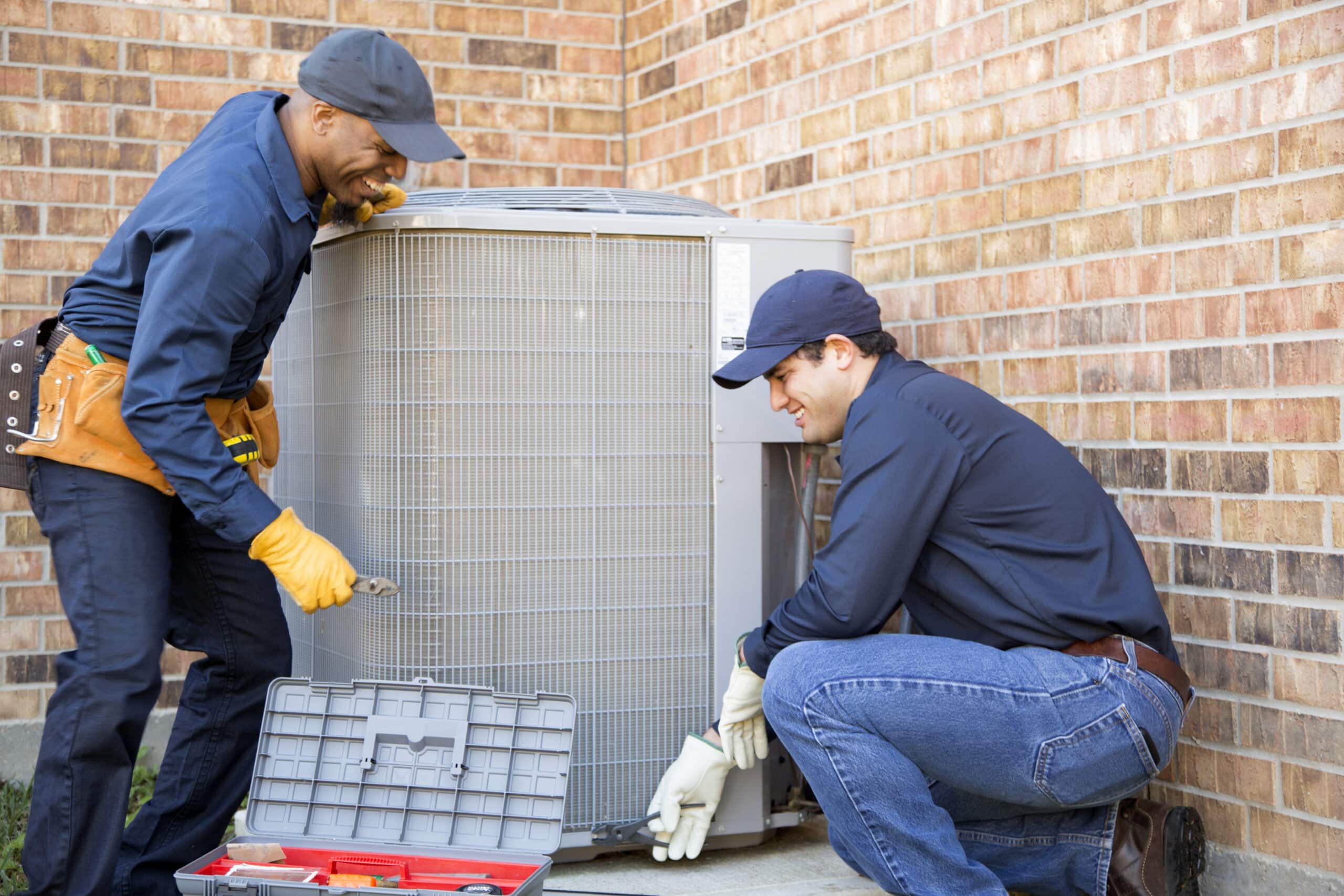 HVAC technician team installing condenser unit
